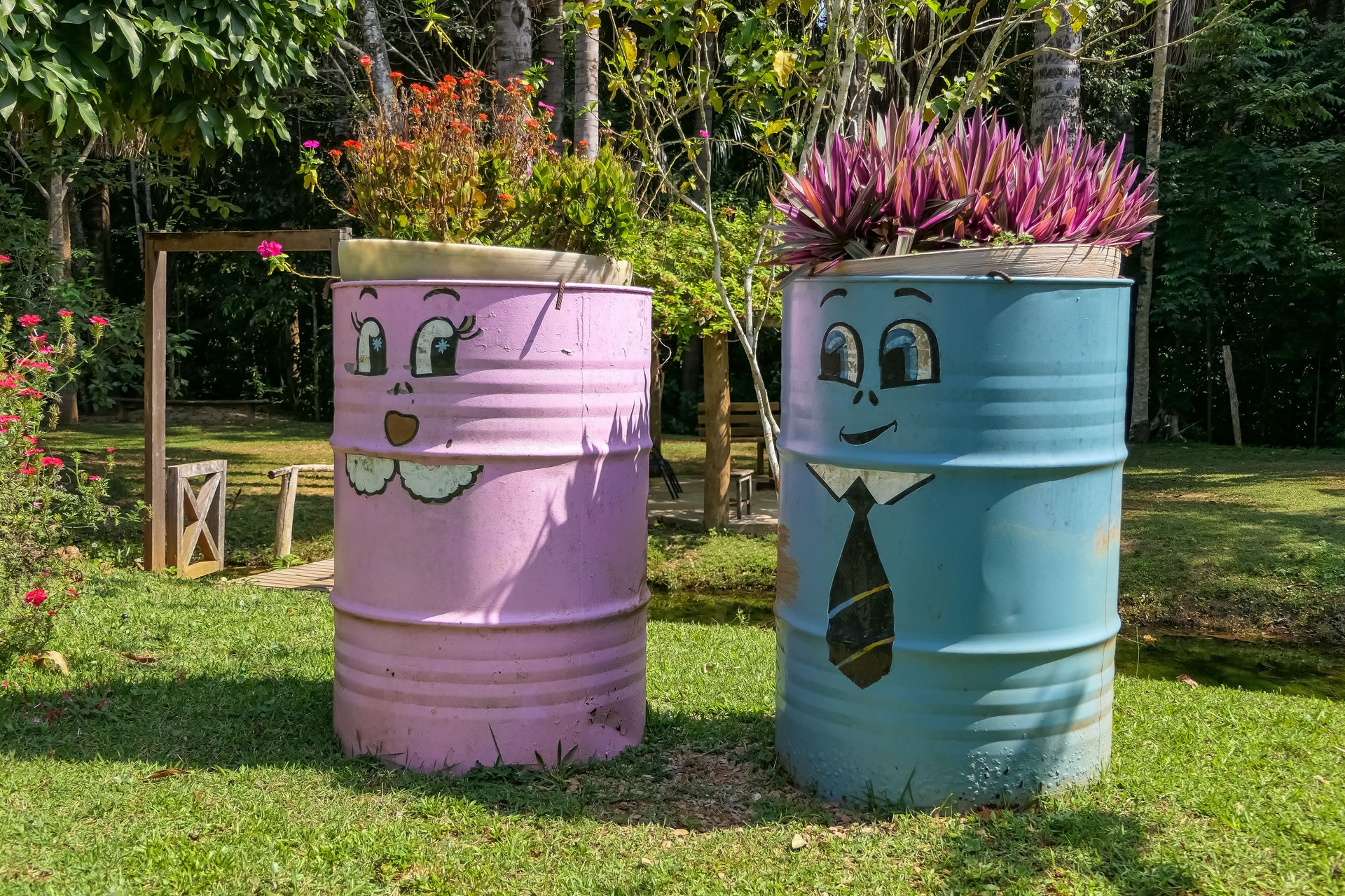 Unique decorated plant pots made of steel drums and colorful painted with funny faces in a garden, Amazonia, San Jose do Rio Claro, Mato Grosso